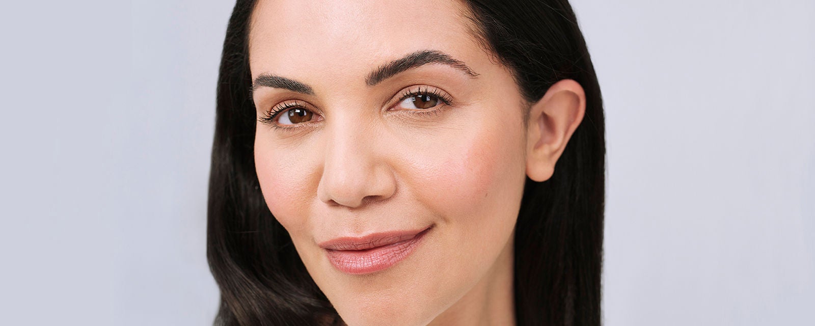 portrait d'une femme brune après injections d'acide hyaluronique anti age de Juvederm