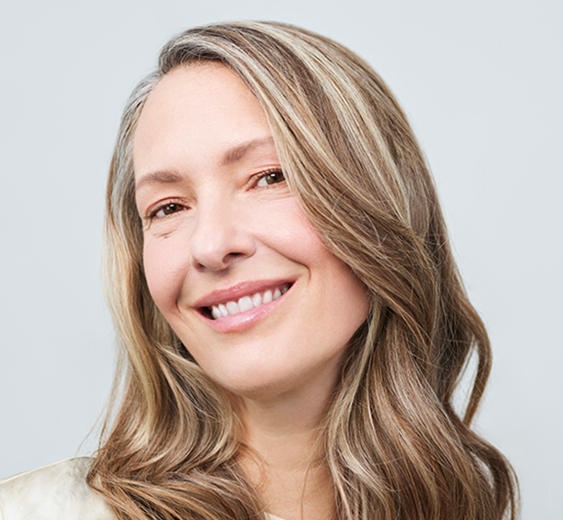 Femme blonde qui sourit après des injections d'acide hyaluronique anti age de Juvederm au visage 