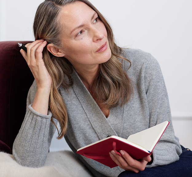 Portrait d'une femme avec un carnet après injections d'acide hyaluronique anti age de Juvederm